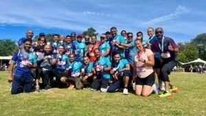 Runners in Revolution team kit celebrating with their medals at Revolution RunFest in Luton